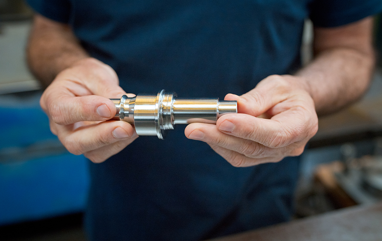 Hands displaying a shiny metal part